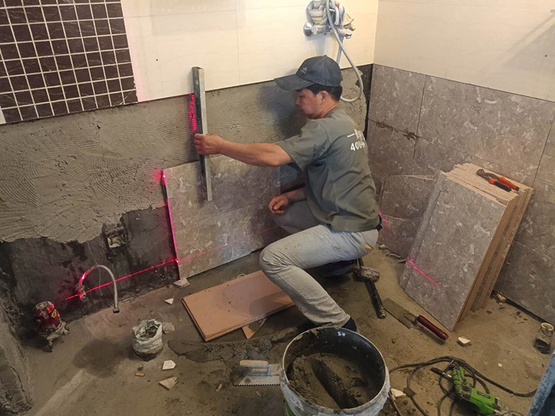 衛(wèi)生間貼磚施工：施工工藝流程; 基層處理--抹底子灰--彈線排磚--侵磚--鑲貼--擦縫--交工驗(yàn)收 用一比三的水泥砂漿打底,打底厚度5~~7mm，待底子灰干六七成干時(shí)候，按圖紙要求，進(jìn)行彈線，排磚。立好皮數(shù)桿，排磚形式有主要兩種直縫和錯(cuò)縫。當(dāng)?shù)孛嬗蟹核臅r(shí)候，注意安排好泛水。侵泡瓷磚，時(shí)間不少于兩個(gè)小時(shí)，陰干通常是3~~5小時(shí)。瓷磚在鑲貼時(shí)候，瓷磚下口坐在八字尺或直尺上。鋪貼的方式有離縫和無縫。鑲貼瓷磚從陽角開始，自下向上貼，瓷磚背面刀灰，貼上用力壓，用鏟刀木柄輕輕敲打，鋪貼時(shí)候砂漿飽滿，缺灰重貼，不得塞灰，貼6~~8塊，用靠尺校正。水管處先鋪周圍整塊磚，后鋪異型磚。最后擦縫。
